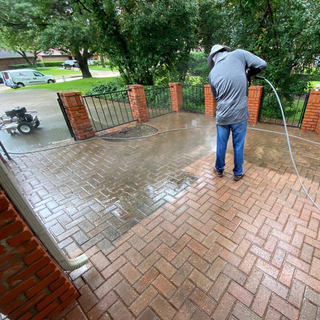 Pressure washing a brick patio to clean moss and stains in OKC